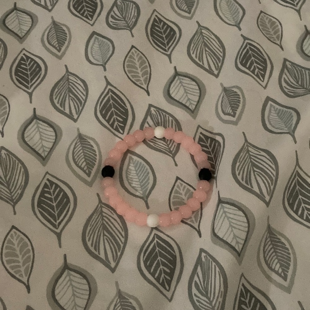 A pink and white and black bracelet
